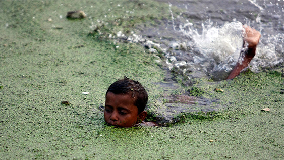 A boy swims in the polluted waters of the Buriganga river in Dhaka, Bangladesh, May 14, 2009